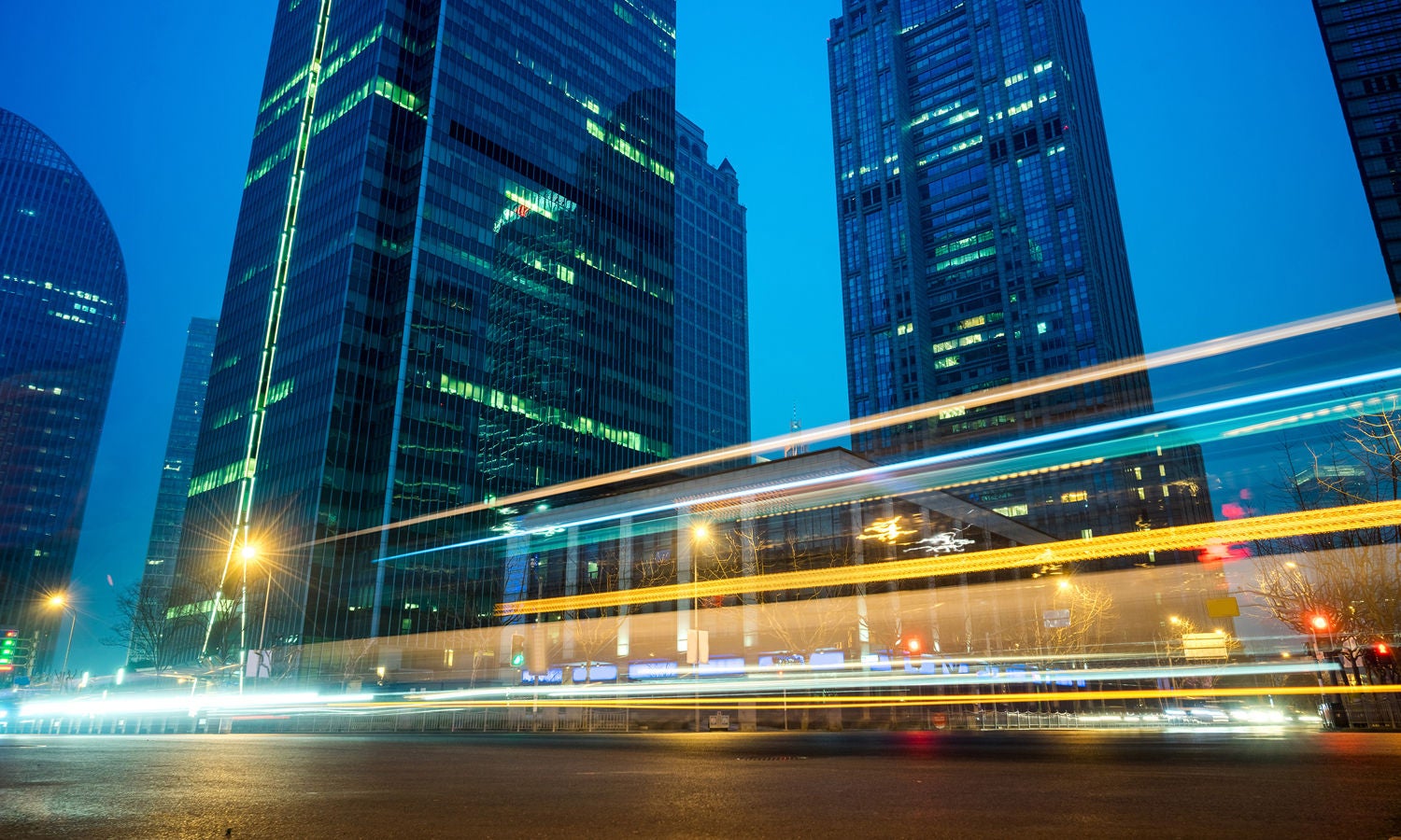 City skyline at dusk with a time-lapse traffic blur